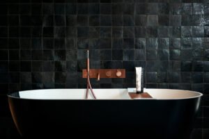 Reclamefoto - badkuip - sfeerfoto - zwarte badkuip met koperen kranen.